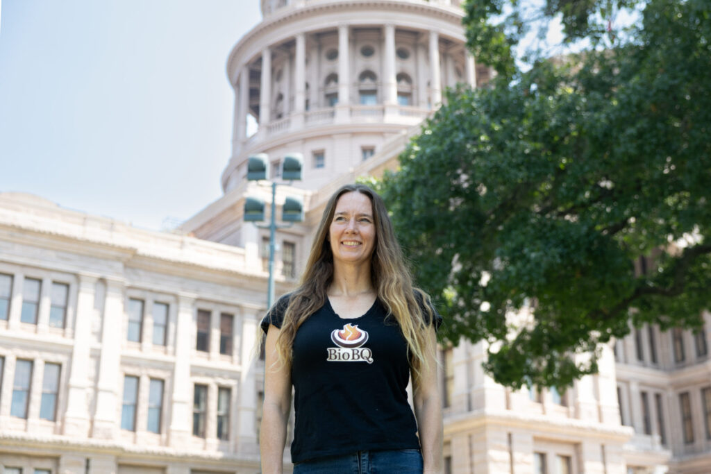 Katie Kam in front of the Texas State Capitol wearing a BioBQ shirt